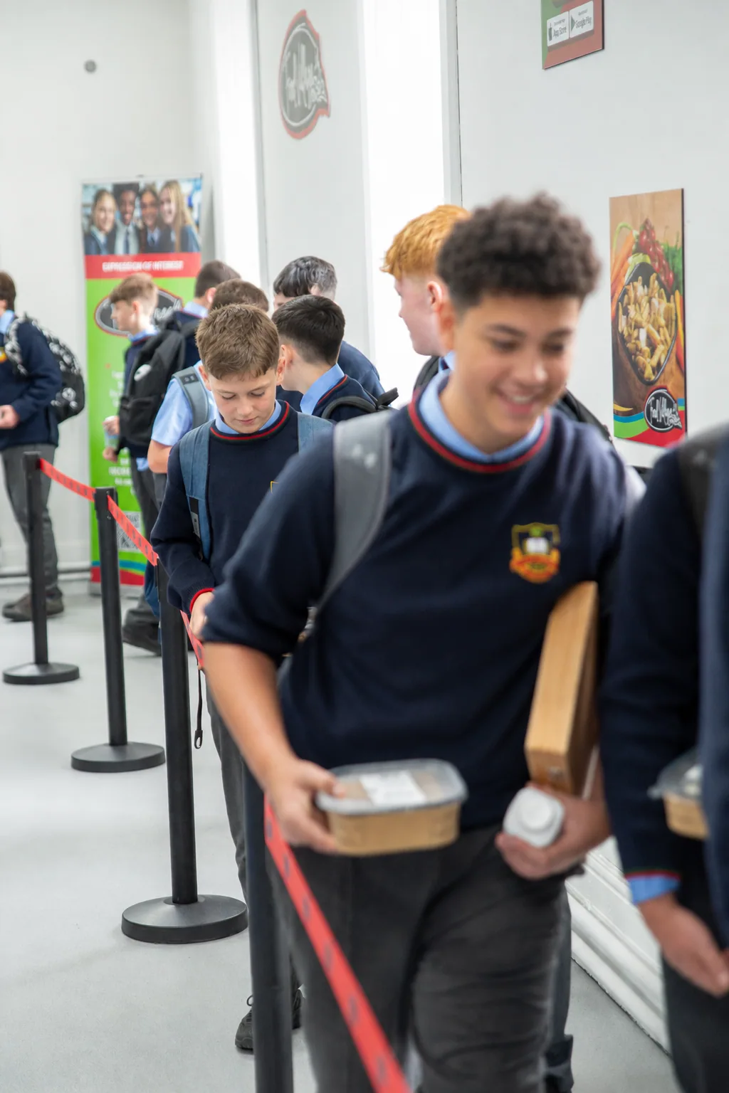 Students in school uniform queuing to collect their Food Village order